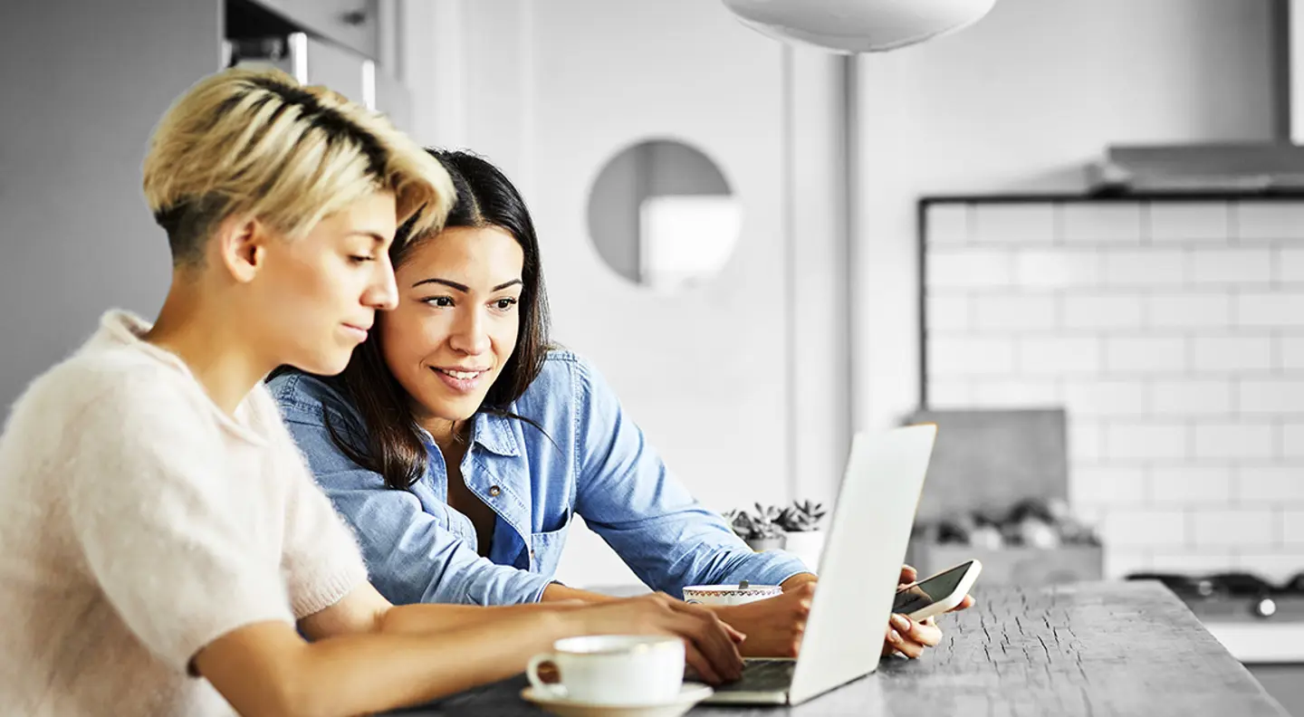 Two people looking at something on a laptop