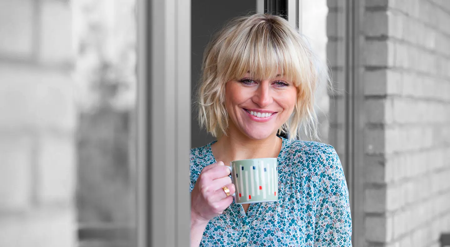 Smiling person drinking a cup of tea